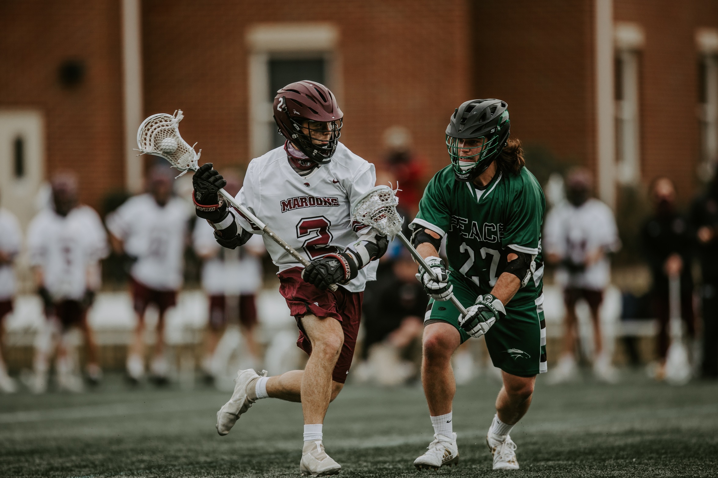 action photo of RC men's lacrosse player Luca Docking with the ball against a defender