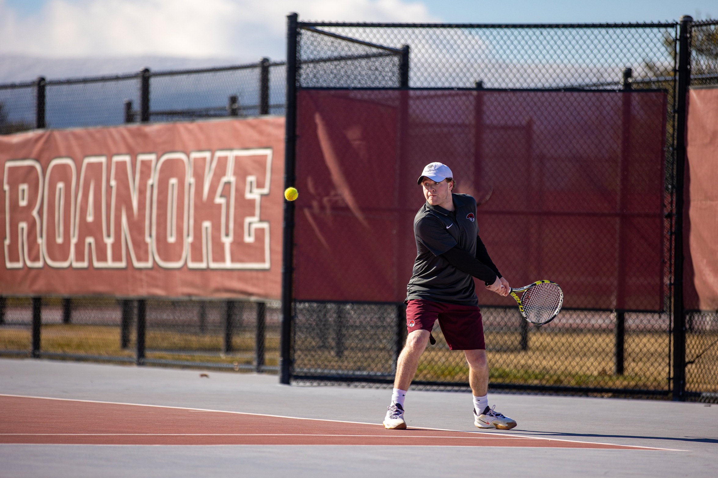 action photo of RC men's tennis player hitting a backhand