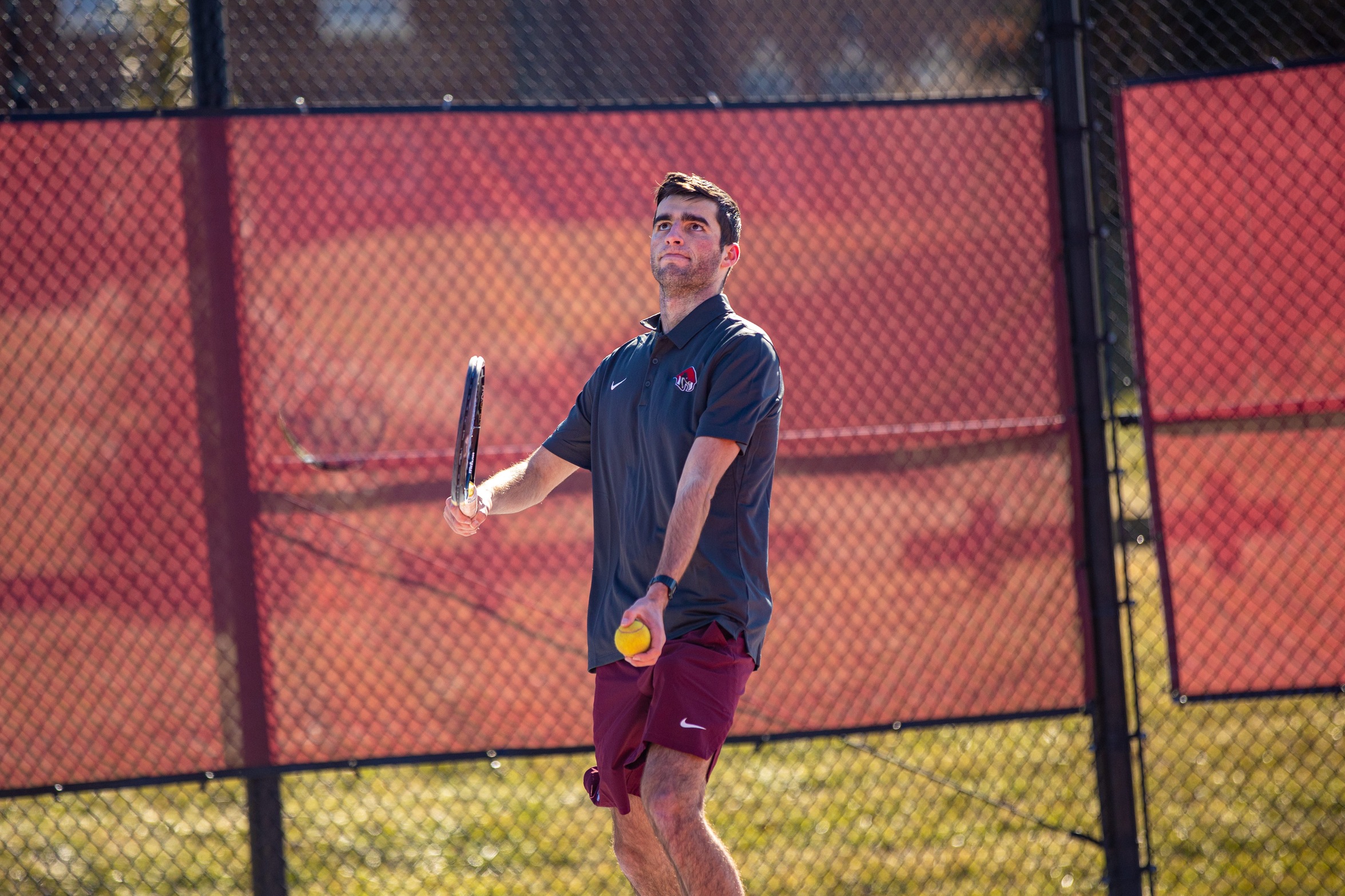 action photo of RC men's tennis player serving