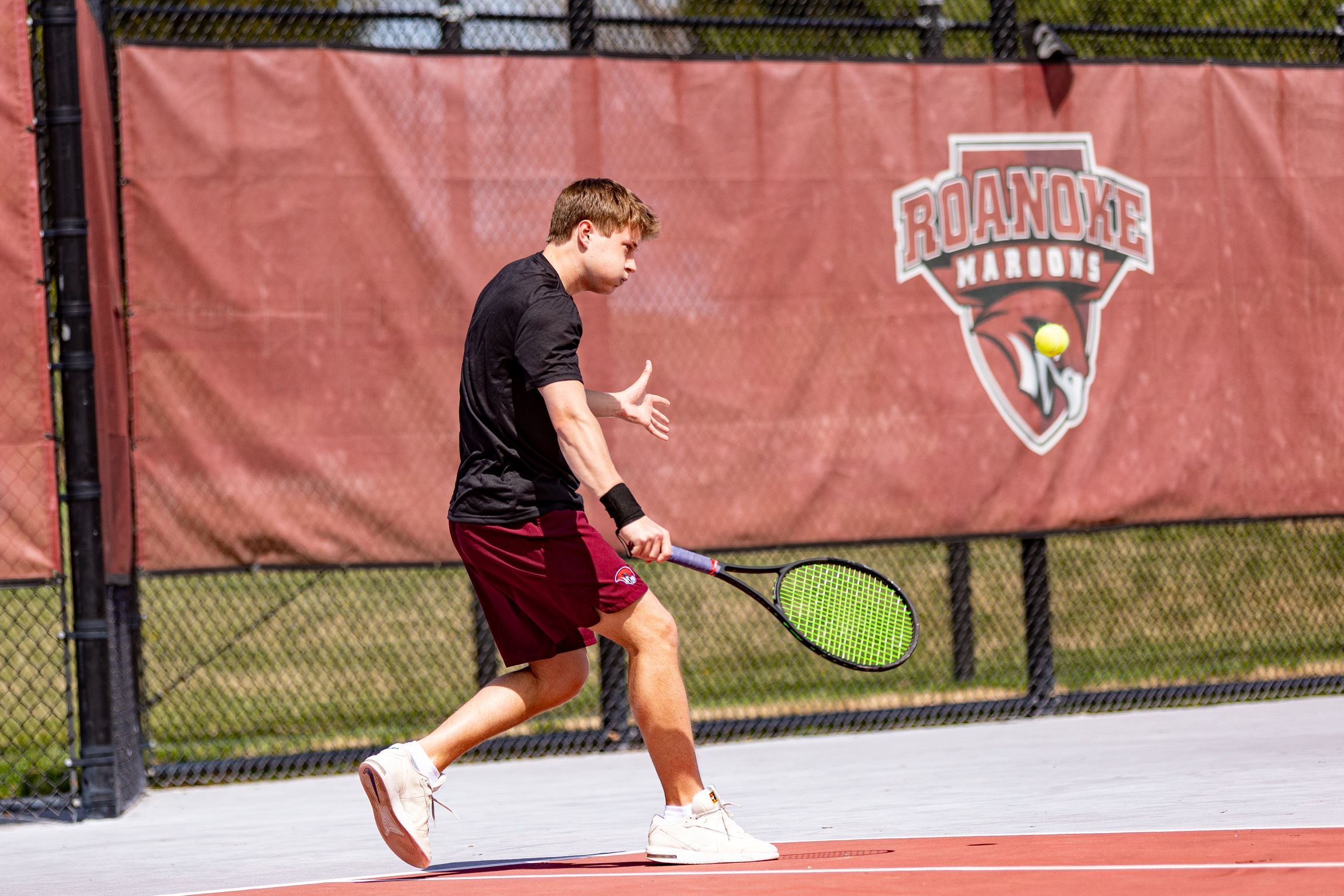 action photo of RC tennis men's player hitting a backhand