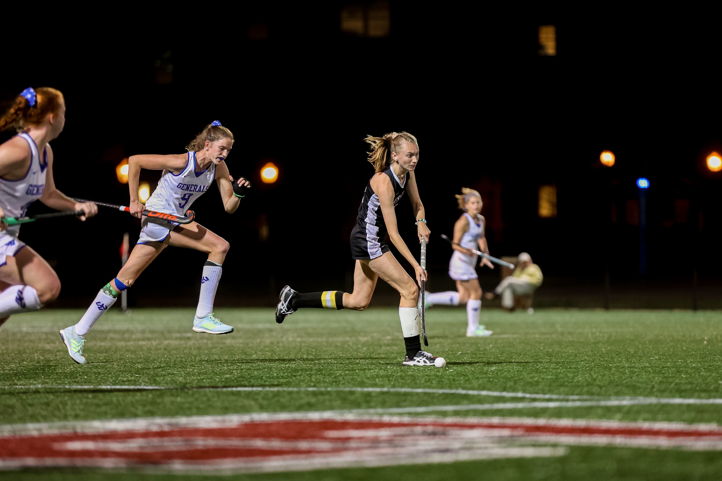 action photo of RC field hockey player Emilee Wooten ahead of two defenders