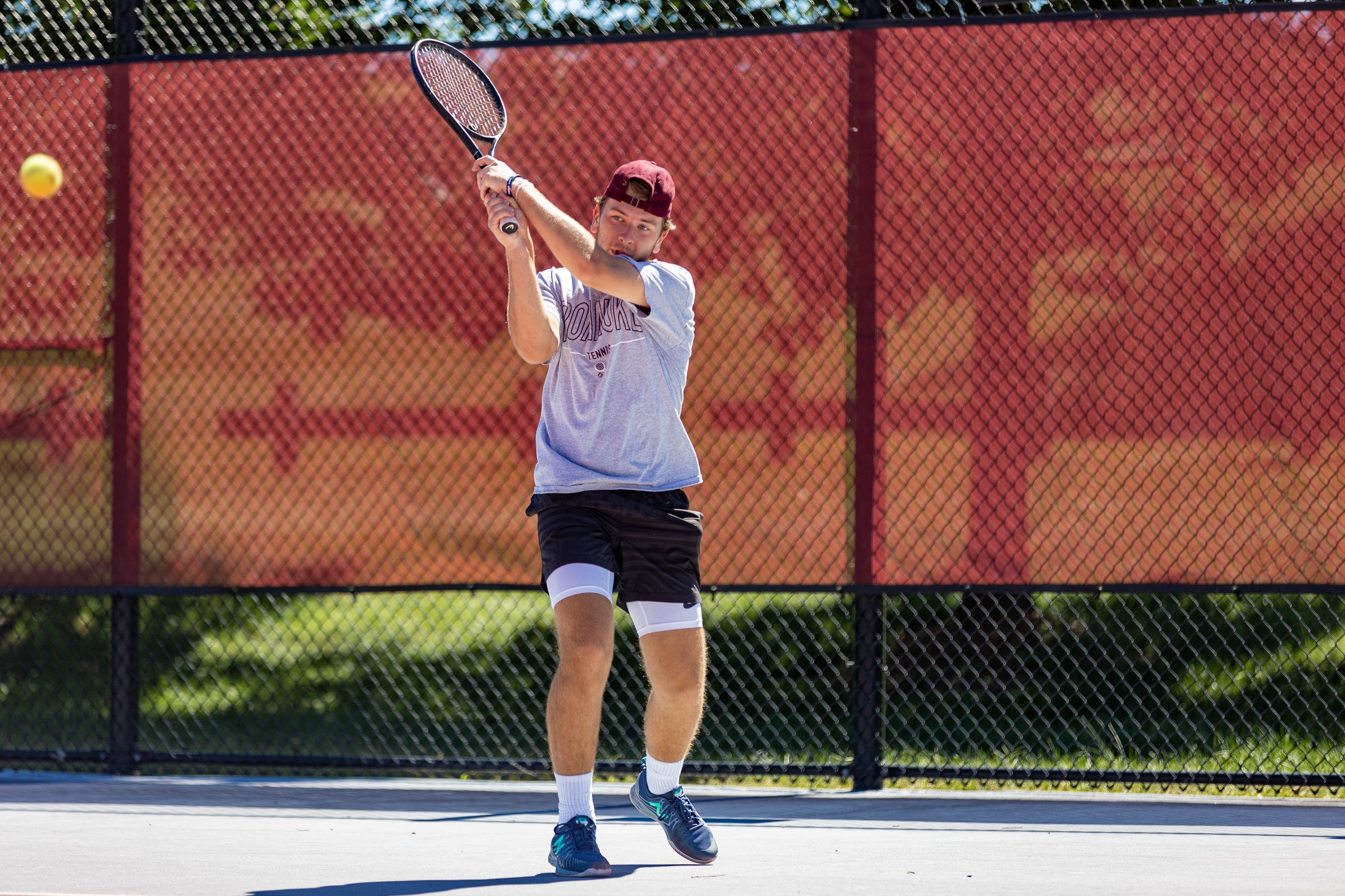 action photo of RC men's tennis player hitting a backhand