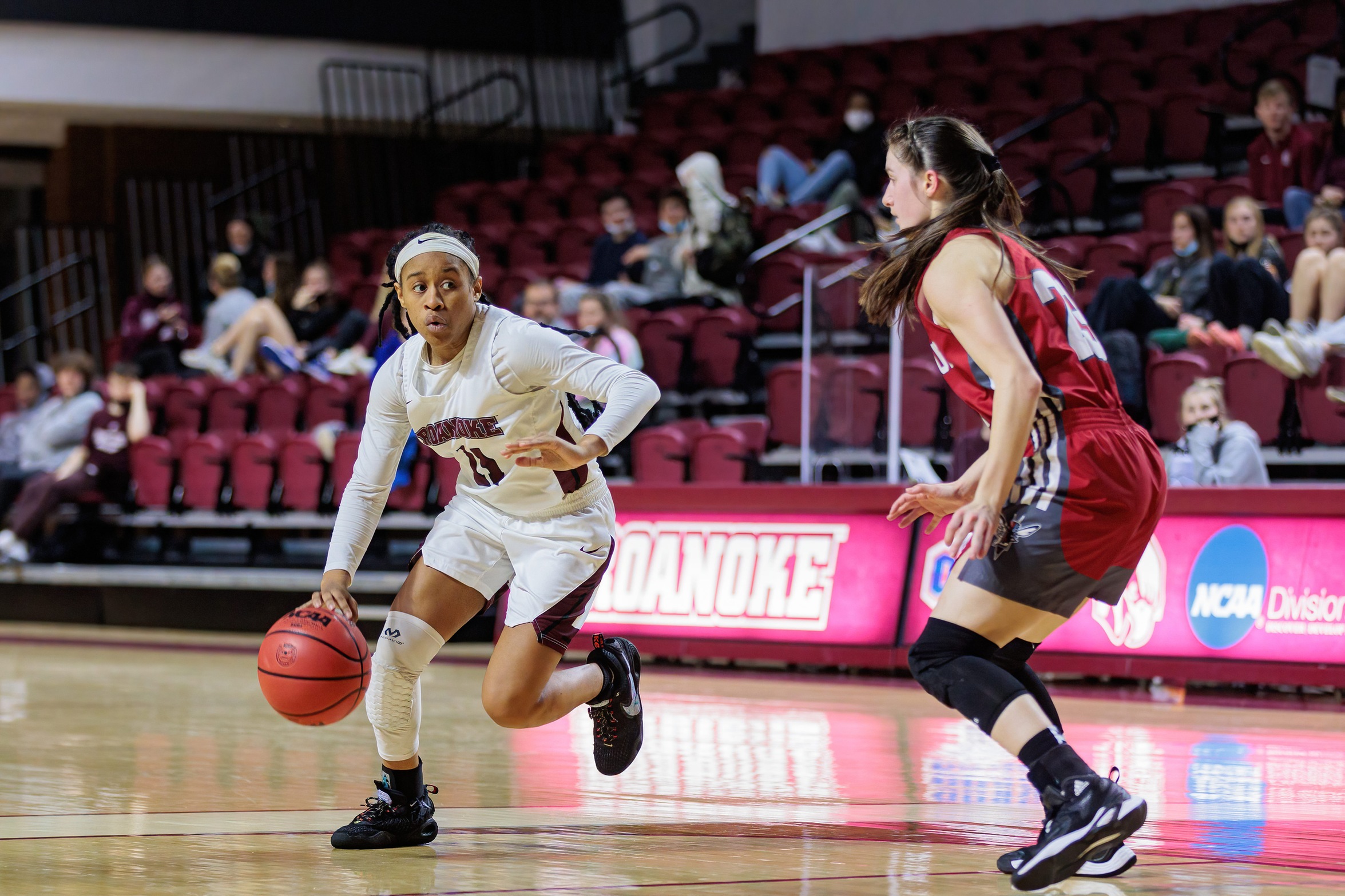action photo of RC WBB guard Whitney Hopson dribbling past a defender