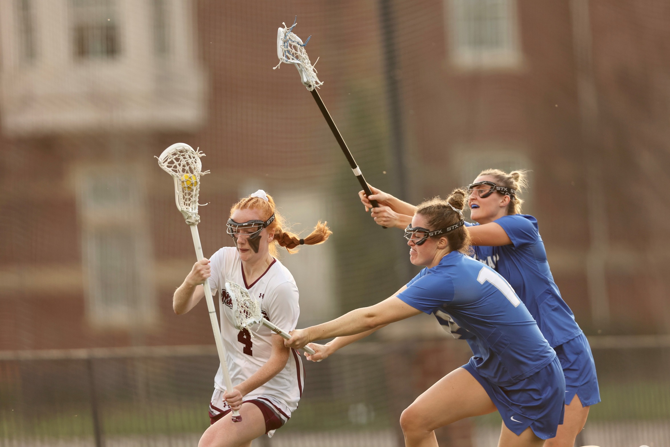 action photo of RC women's lacrosse player Molly Kasemeyer going past two defenders