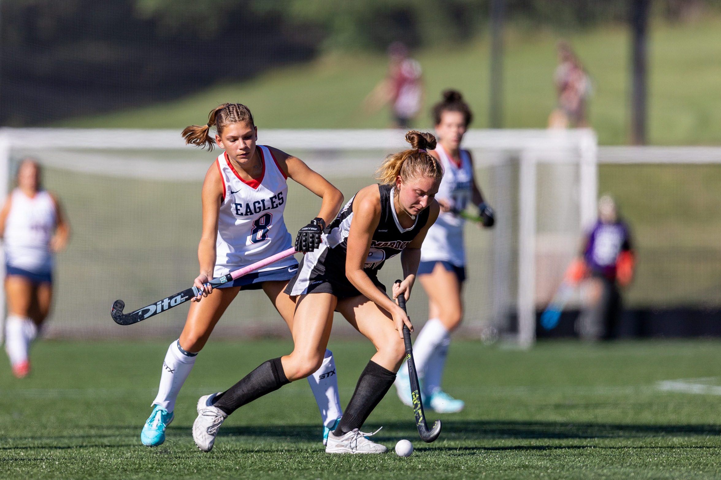 action photo of RC field hockey player dribbling past a defender