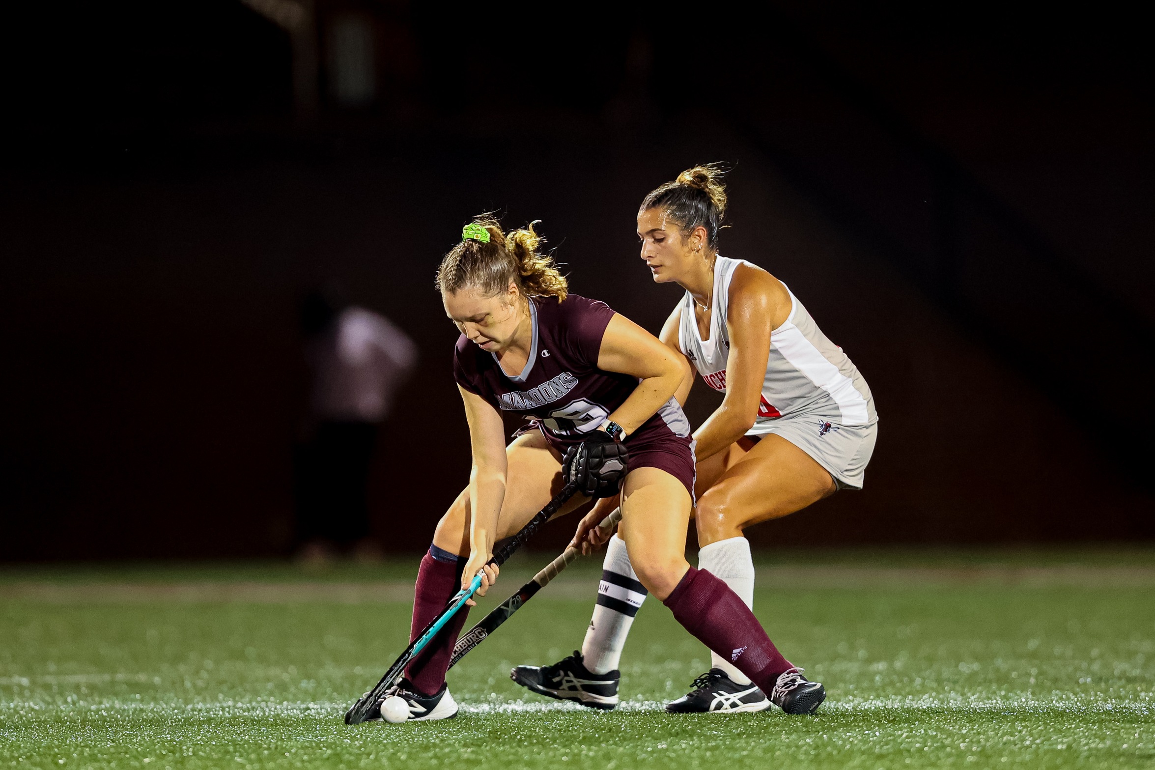 action photo of RC field hockey defender Hope Keller with a player on her back