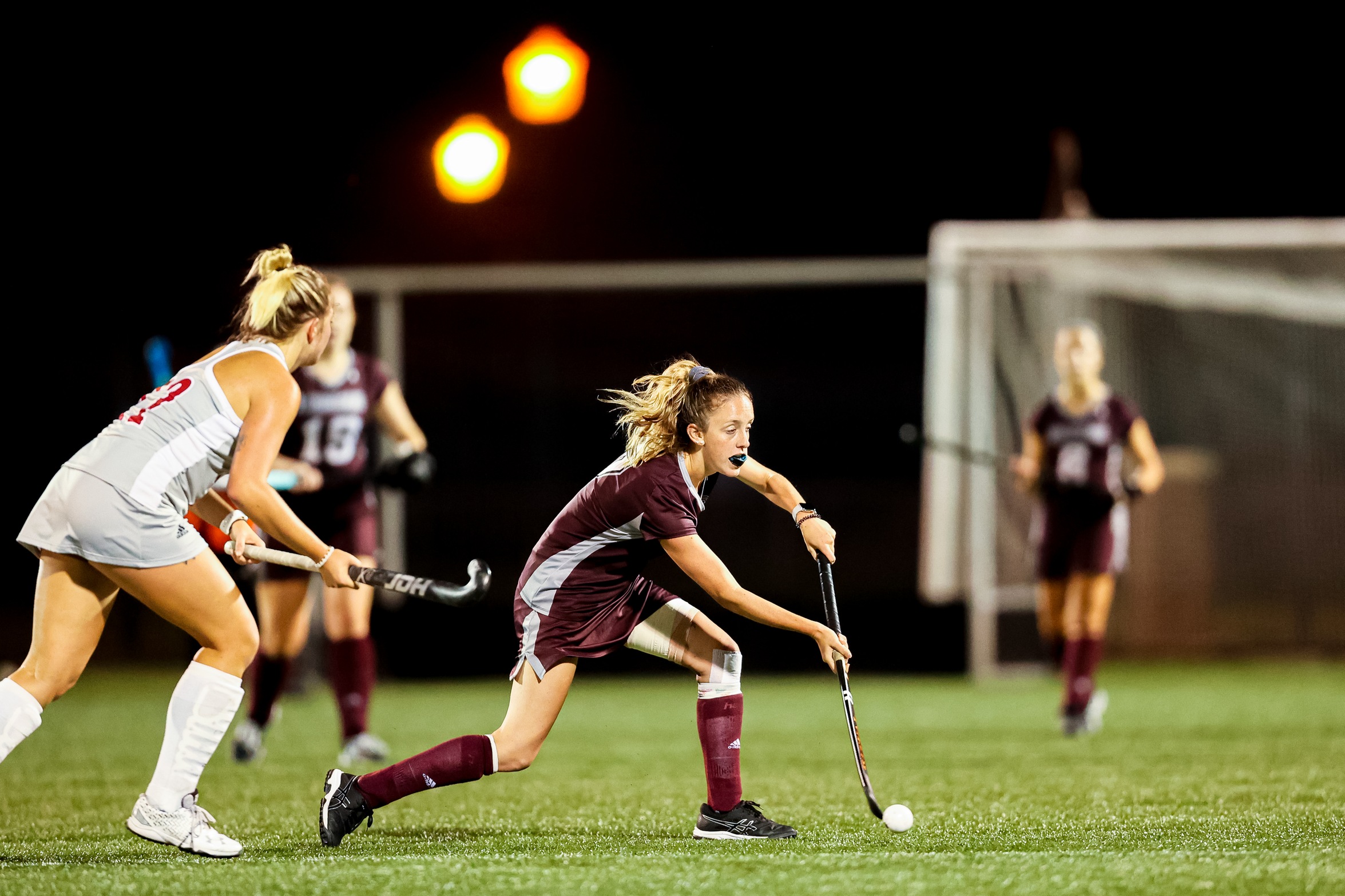 action photo of RC field hockey player Marth Hurley dribbling past a defender