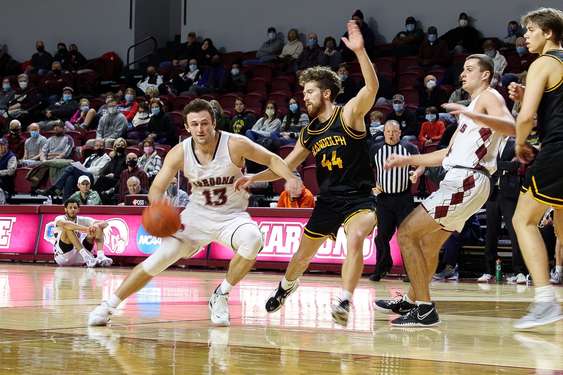 action photo of RC MBB player Tripp Greene dribbling past a defender
