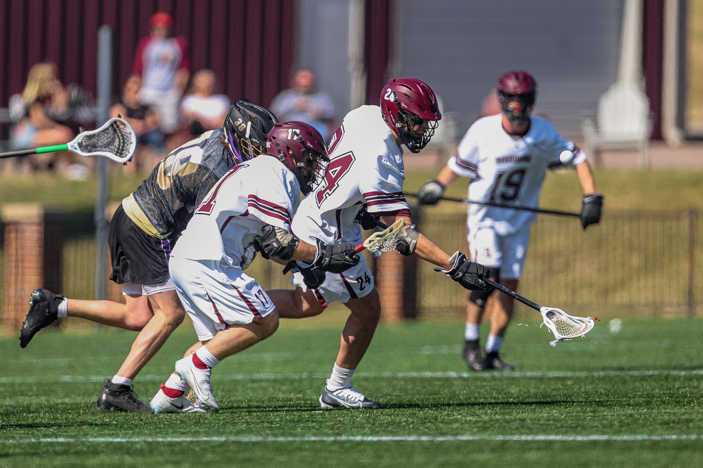 action photo of RC MLAX defensemen Carson Peck and RT Williamson going after a ground ball