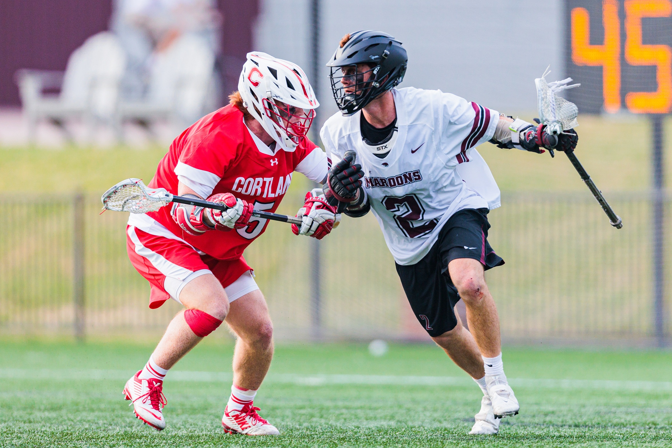 action photo of RC men's lacrosse player Luca Docking with the ball against a defender