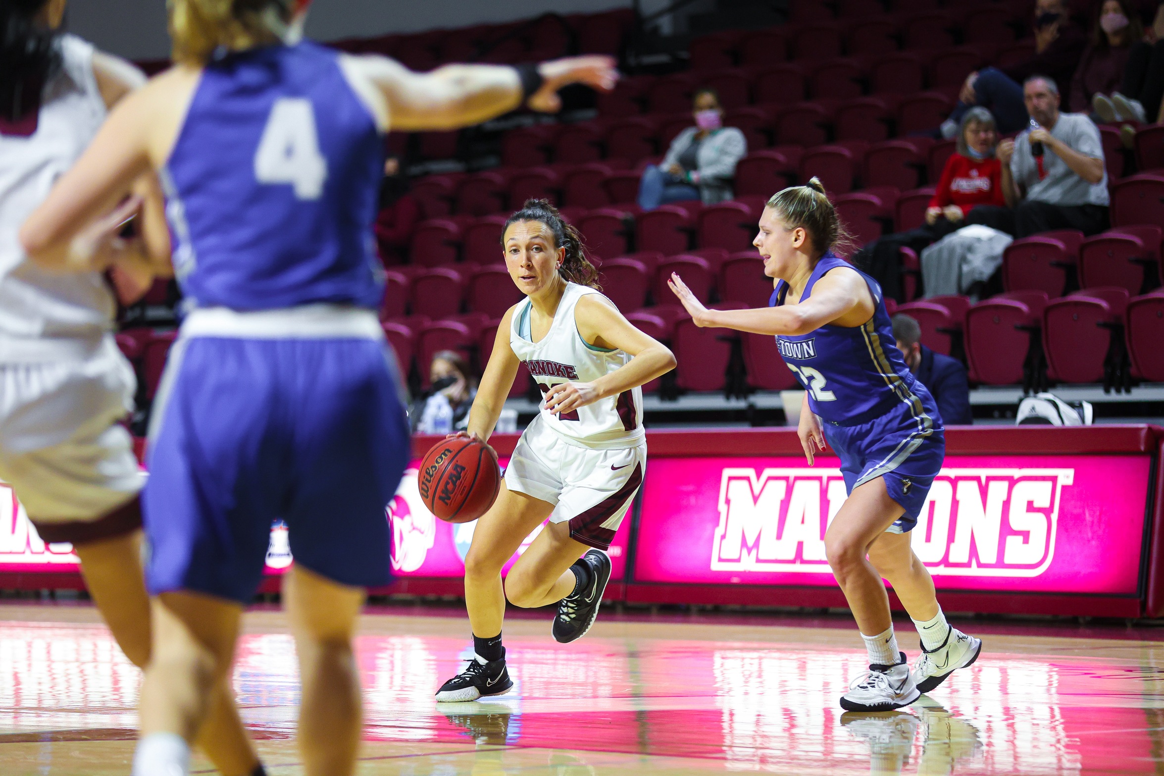 action photo of RC women's basketball Kristina Harrel driving to the basket past a defender 