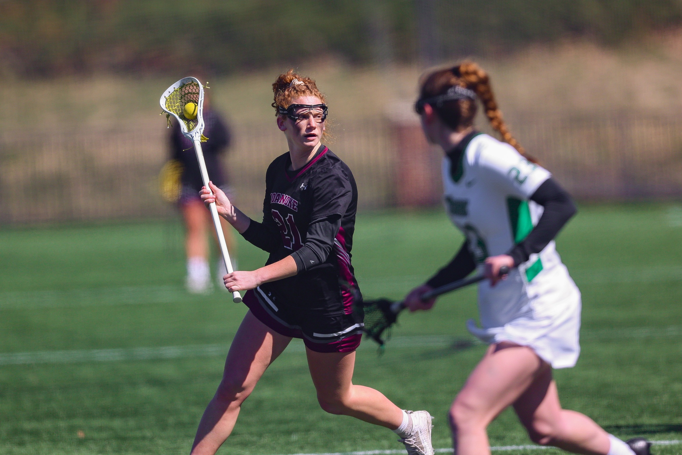 action photo of RC women's lacrosse midfielder Emerson Foster against a defender