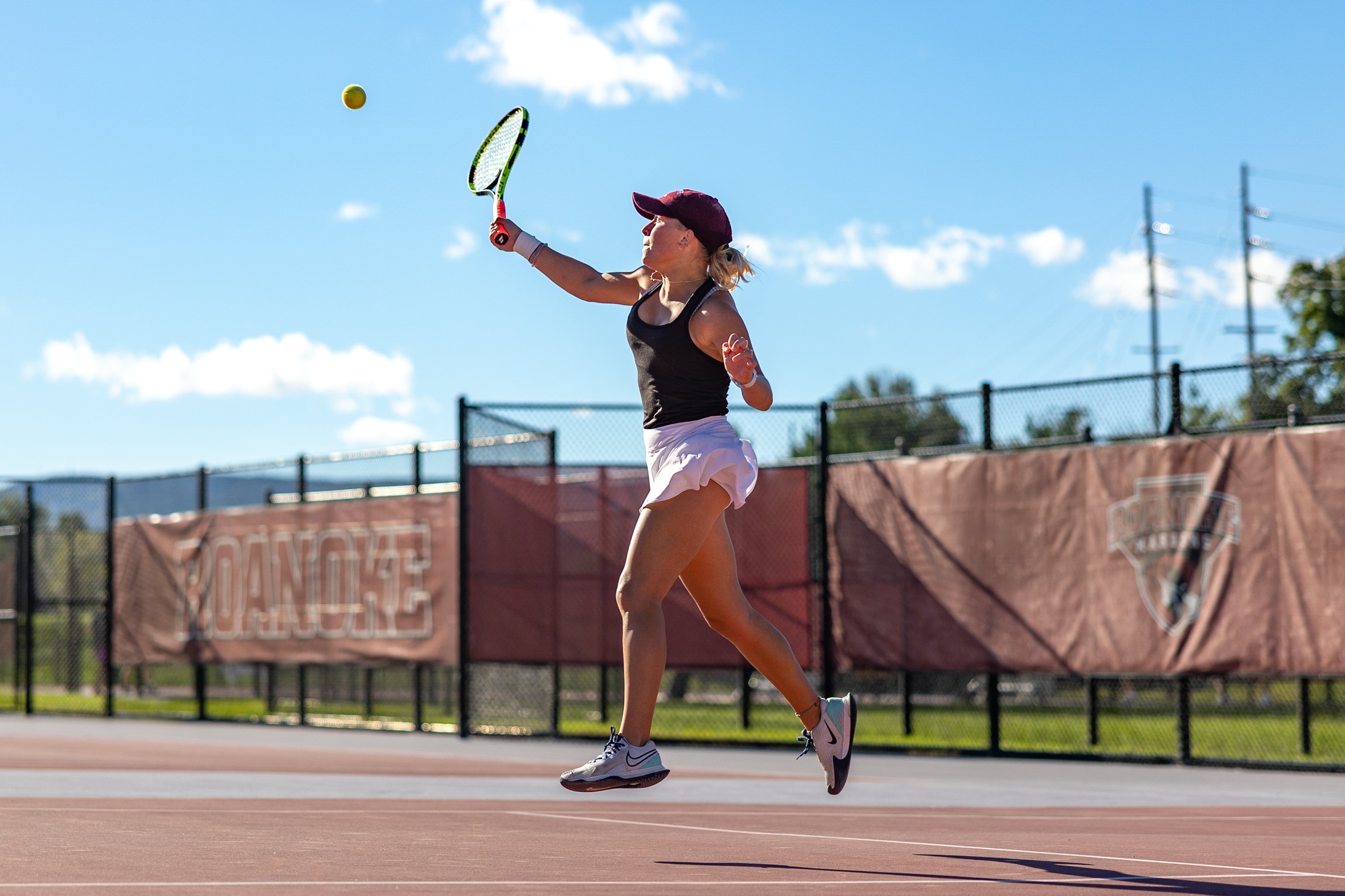 action photo of RC women's tennis player hitting an overhead